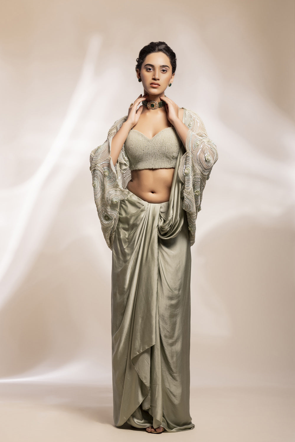 Cape with cut out sleeves with a bustier and drape lungi skirt