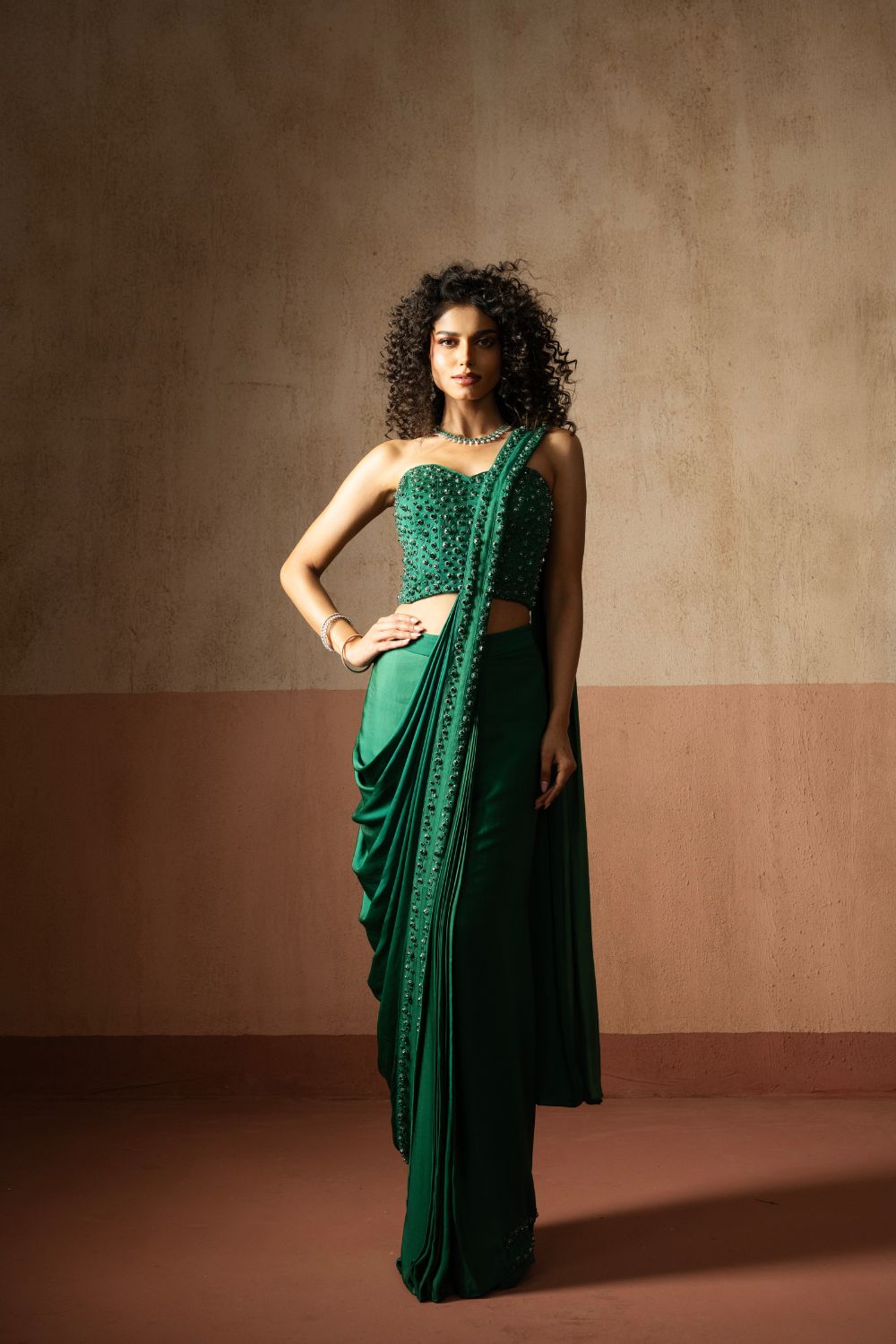 Predraped, emerald green hand embroidered satin saree with corset blouse