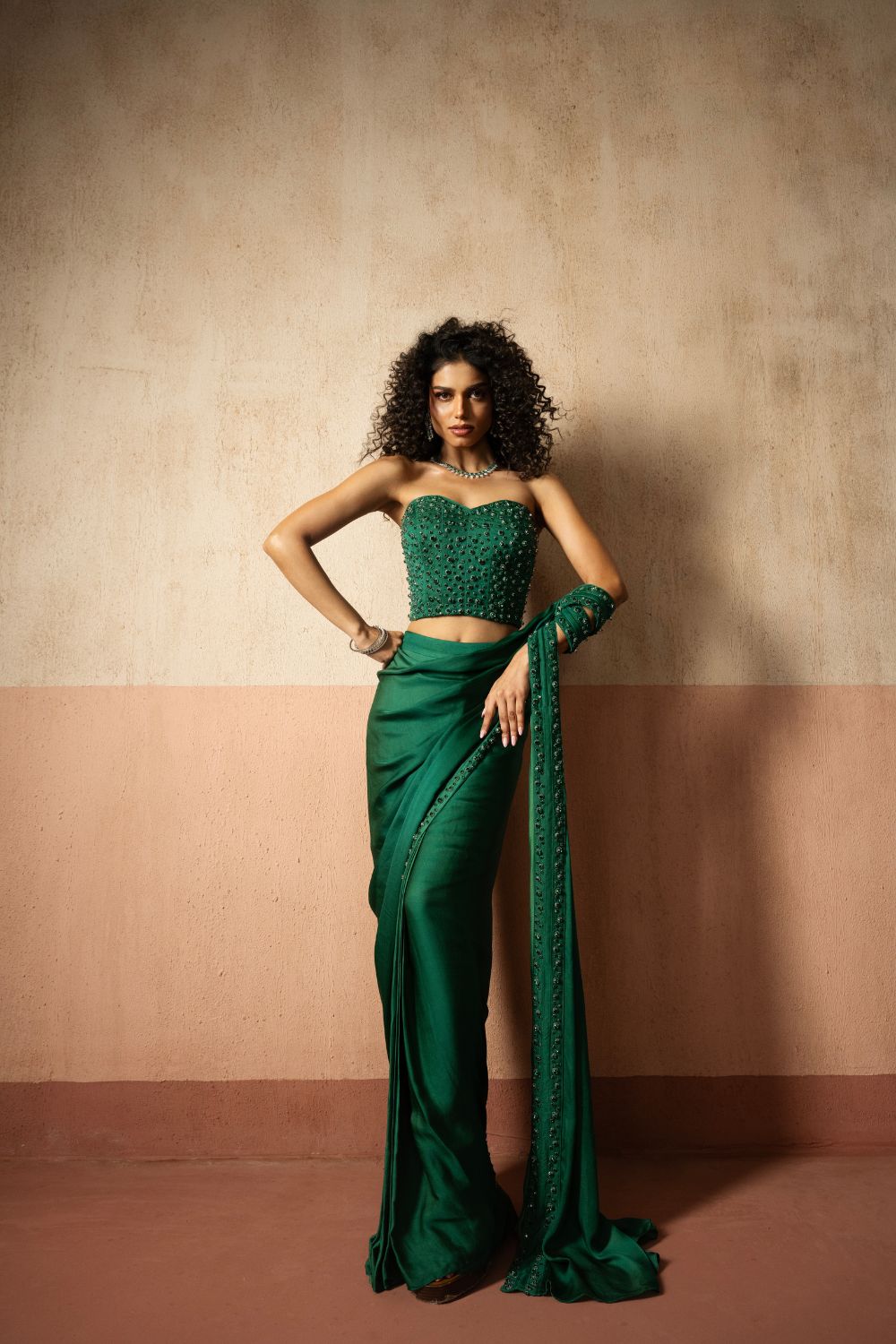 Predraped, emerald green hand embroidered satin saree with corset blouse