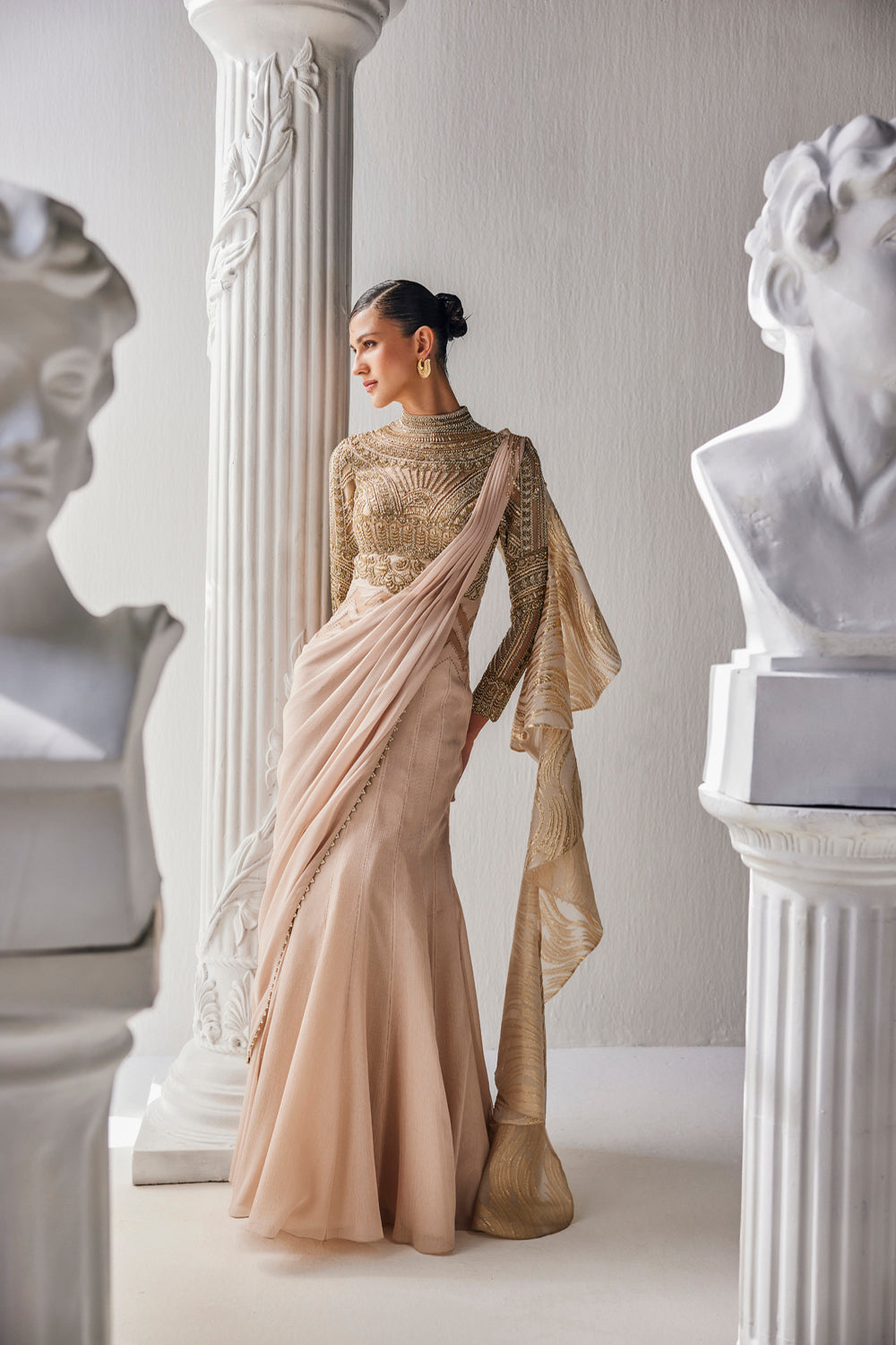 Golden Cream Draped Saree In Luxurious Shimmer Chiffon Offset With A Zardozi Blouse And An Elaborate High Neckline.